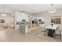 Open-concept living space with a modern kitchen, a dining area, and a comfortable living room, all bathed in natural light at 6056 Willow Rock St, Las Vegas, NV 89135