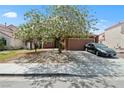 Charming single-story home with a well-maintained lawn, mature trees, and a two-car garage, situated in a friendly neighborhood at 619 Zalataia Way, North Las Vegas, NV 89031