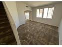 Spacious carpeted living room with ample natural light and an archway to another room at 7282 Quarterhorse Ln, Las Vegas, NV 89148