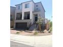 Two-story home featuring a balcony, two-car garage, and brick paved driveway at 7499 Lodano Ave, Las Vegas, NV 89113