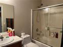 A functional bathroom featuring a shower-tub combo, standard fixtures, and a sliding glass door at 7812 Sedalia St, Las Vegas, NV 89139