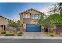 Traditional two-story home featuring a blue garage door and front yard landscaping at 9327 S Chieftain St, Las Vegas, NV 89178