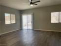 Bright living room featuring modern ceiling fan, wood-look floors and sliding glass doors at 9333 Leaping Deer Pl # 103, Las Vegas, NV 89178