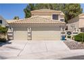 Well-maintained home featuring a tile roof, manicured shrubs, and a convenient two-car garage at 9552 Wooden Pier Way, Las Vegas, NV 89117