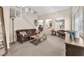 Comfortable living room features neutral tones, plush seating, and staircase access at 9872 Chief Sky St, Las Vegas, NV 89178