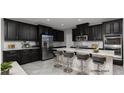 Modern kitchen with black cabinetry, stainless steel appliances, and a marble-look island at 1015 Solana Crest St, Henderson, NV 89052
