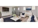 Bright living room featuring modern white furniture, a dark blue rug, and contemporary art at 1015 Solana Crest St, Henderson, NV 89052