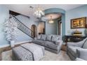 Comfortable living room featuring stylish decor, elegant lighting, and a staircase at 10370 Sweet Laurel St St, Las Vegas, NV 89178