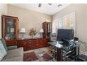 Well-lit home office with built-in cabinets, a glass desk, and comfortable seating at 10370 Sweet Laurel St St, Las Vegas, NV 89178
