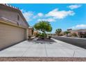 View of a single-story home featuring a two-car garage, desert landscaping, and a paved driveway at 10532 Sea Palms Ave, Las Vegas, NV 89134