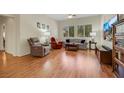 Spacious living room with hardwood floors, comfortable furniture, and natural light from large windows at 10532 Sea Palms Ave, Las Vegas, NV 89134