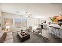 Open concept living area with natural light, ceiling fan, dining area, and breakfast bar with kitchen view at 1180 Via Vinci, Henderson, NV 89052