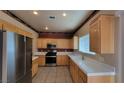Efficient kitchen equipped with stainless steel appliances, oak cabinets, and white tile countertops at 1211 Silver Knoll Ave, Las Vegas, NV 89123