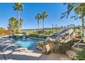 Stunning backyard pool and spa area with rock waterfall feature and lush tropical landscaping at 151 Cliff Valley Dr, Las Vegas, NV 89148