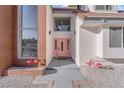 Close up of front entrance, with modern brick and stucco design, flamingo statues, and a stylish light pink front door at 2160 Pueblo Cir, Las Vegas, NV 89169