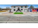 Two-story home showcasing a freshly painted white exterior, black trim, front yard, and driveway at 2521 Richfield Blvd, Las Vegas, NV 89102