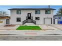 Two-story home showcasing a freshly painted white exterior, black trim, manicured front yard, and attached garage at 2521 Richfield Blvd, Las Vegas, NV 89102