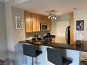 Charming kitchen with stainless steel appliances, wood cabinets, granite countertops, and breakfast bar at 260 E Flamingo Rd # 228, Las Vegas, NV 89169