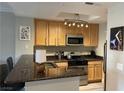 Well-lit kitchen featuring stainless steel appliances, wood cabinetry, and granite countertops at 260 E Flamingo Rd # 228, Las Vegas, NV 89169