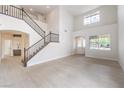 Spacious open-concept living room features a staircase with dark metal handrails and lots of natural light at 3065 Blue Monaco St, Las Vegas, NV 89117