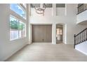 Bright, open living room with wood floors, large windows, and access to the kitchen at 3065 Blue Monaco St, Las Vegas, NV 89117