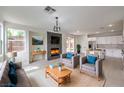 Cozy living room featuring a fireplace with decorative mantel and an open layout to the kitchen at 3065 Blue Monaco St, Las Vegas, NV 89117