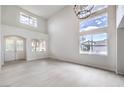 Bright living room with high ceilings, large windows, and a double-door entryway at 3065 Blue Monaco St, Las Vegas, NV 89117