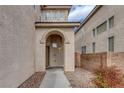 Arched entryway featuring stone accents, a modern front door, and desert landscaping at 3964 Irvin Ave, Las Vegas, NV 89141