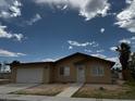 Tan single story home features a two car garage, desert landscaping, and neutral color scheme at 4189 Studio St, Las Vegas, NV 89115