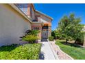 Beautiful home entrance with lush landscaping, a stone accent wall, and decorative plants at 4835 Willow Glen Dr, Las Vegas, NV 89147