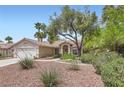 Lovely single-story home with a red tiled roof, beautiful landscaping and a two-car garage at 5529 Cranwood Ct, Las Vegas, NV 89130