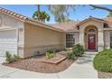 Charming single-story home with a red front door, well-maintained landscaping, and a two-car garage at 5529 Cranwood Ct, Las Vegas, NV 89130