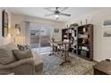 Cozy living room with a ceiling fan, a comfortable couch, a patterned rug, and a sliding glass door to the backyard at 6848 Sunflower Fields St, North Las Vegas, NV 89086