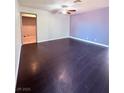Spacious living room featuring dark wood-look floors and ceiling fan at 7123 Kenwood St, Las Vegas, NV 89147