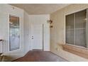 Front entry featuring the unit number, exterior light fixture, two windows, and a solid white front door at 7173 S Durango Dr # 307, Las Vegas, NV 89113