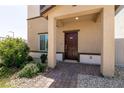Inviting entryway showcasing a covered porch, a dark wood door, and well-maintained landscaping at 7302 Sunray Point St, North Las Vegas, NV 89084