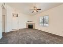 Spacious living room with fireplace, plush carpet, large window, and ceiling fan at 8805 Jeffreys St # 2073, Las Vegas, NV 89123