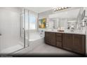 Bright bathroom with double vanity, soaking tub, and glass-enclosed shower at 9687 Biedler Ct # Lot 2, Las Vegas, NV 89178
