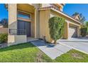 Inviting home entrance with a double door, manicured green lawn, and small shrubbery at 10241 Regents Cross Pl, Las Vegas, NV 89144