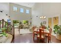Open-concept living room with high ceilings and natural light with stair access at 10697 Acacia Park Pl, Las Vegas, NV 89135