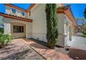 Side view of a stucco home with a brick walkway and mature landscaping at 11444 Steponia Bay St, Las Vegas, NV 89141