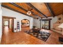 Open-concept living room with wood-beamed ceiling, Saltillo tile floors, and a fireplace at 1320 Daytona St, Pahrump, NV 89048