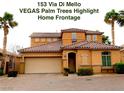 Inviting two-story home featuring an attached two car garage and lush palm trees enhancing curb appeal at 153 Via Di Mello, Henderson, NV 89011