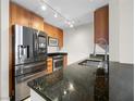 Close-up of kitchen with stainless appliances, granite countertops, and wood cabinetry at 200 W Sahara Ave # 1703, Las Vegas, NV 89102