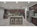Bright kitchen showcasing a center island with barstool seating, stainless steel appliances, and dark wood cabinetry at 205 Piedmont Alps St, Henderson, NV 89012