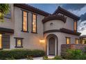 Welcoming entrance featuring an arched doorway and lush landscaping at 2435 Granada Bluff Ct, Las Vegas, NV 89135
