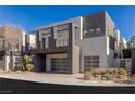 Contemporary home showcasing a two-car garage and a second-story balcony with metal railings at 2672 Mystere Ct, Las Vegas, NV 89117