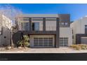 Modern two-story home featuring a three-car garage and minimalist landscaping at 2672 Mystere Ct, Las Vegas, NV 89117
