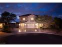 Charming two-story home with a three-car garage and a beautifully landscaped front yard at dusk at 2900 Valvent Ct, Henderson, NV 89044