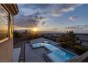 Stunning view of a modern pool and spa area with mountain views at sunset at 2900 Valvent Ct, Henderson, NV 89044